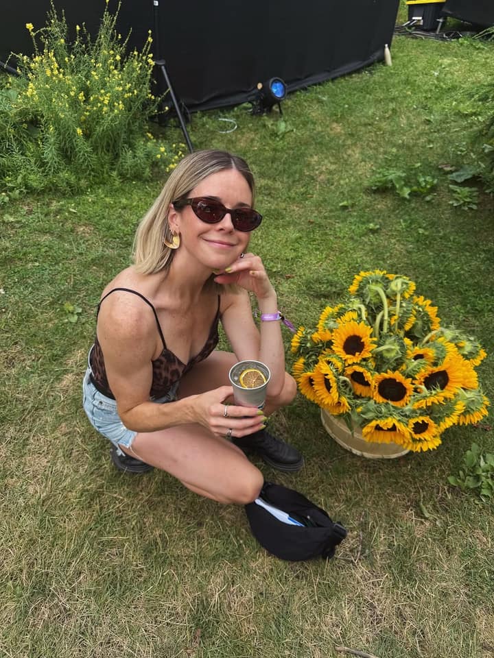 Sabrina Cournoyer met un genou à terre devant Osheaga, tournesol à la main
